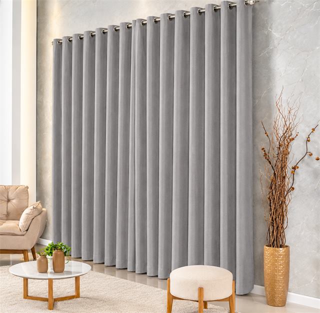 Cortina cinza de ilhós instalada em varão numa sala de estar